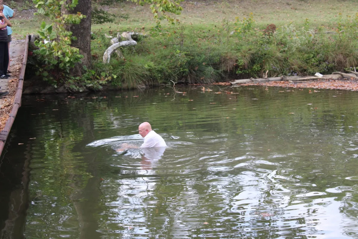 Pastor Michael Johnston baptizing a believer in the river